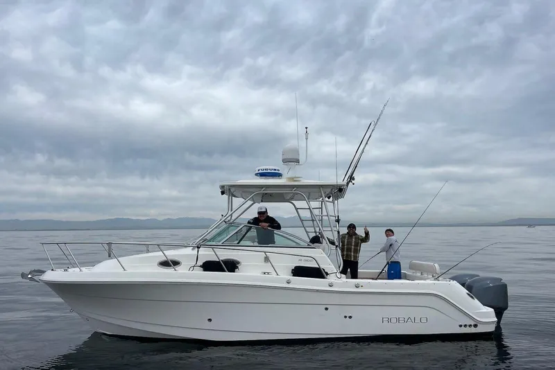 The Image of 2007 Robalo R305 Walkaround boat on calm water with cloudy sky. - 0