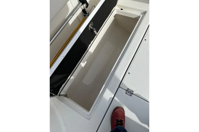 Slide: The Image of 2007 Robalo R305 Walkaround boat storage compartment with open lid and visible foot. - 15