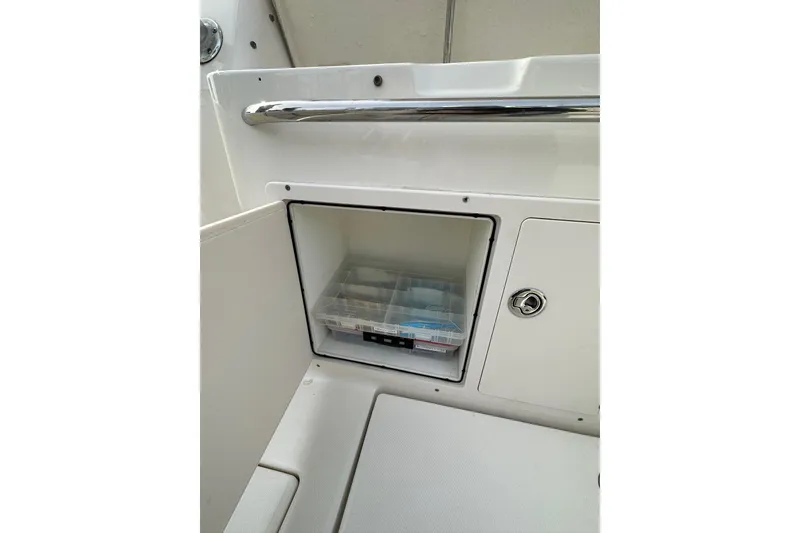 Slide: The Image of 2007 Robalo R305 Walkaround storage compartment with tackle box inside. - 17