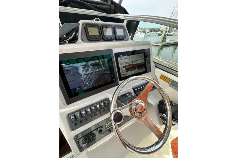 Slide: The Image of 2007 Robalo R305 Walkaround helm with modern navigation displays and controls. - 21