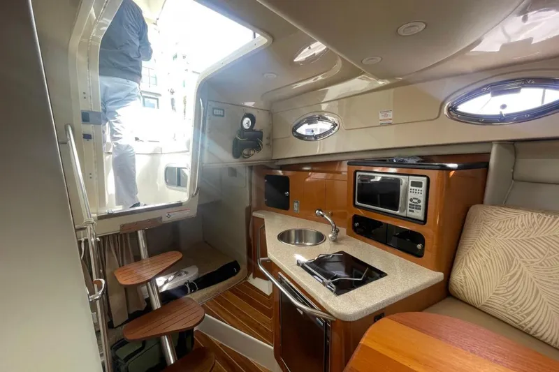 Slide: The Image of 2007 Robalo R305 Walkaround cabin interior with kitchenette and seating area. - 24