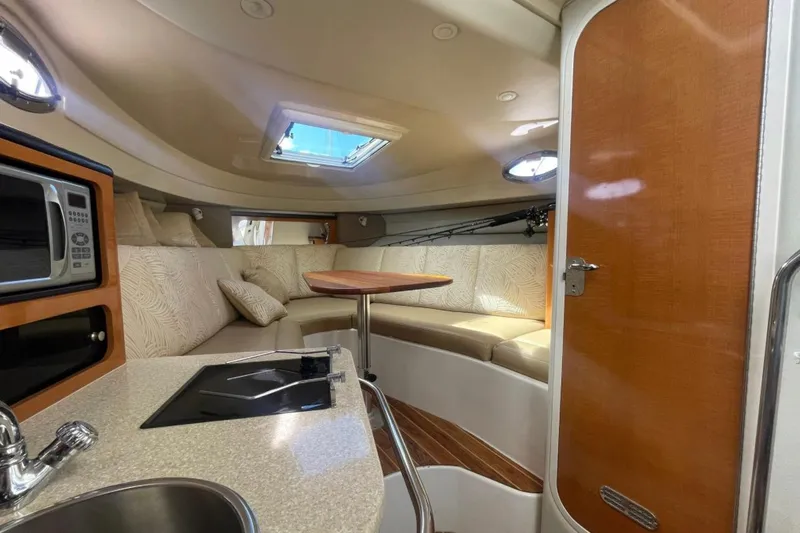Slide: The Image of 2007 Robalo R305 Walkaround cabin interior with kitchenette, seating, and skylight. - 25