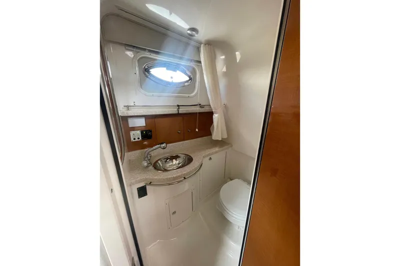 Slide: The Image of 2007 Robalo R305 Walkaround boat bathroom with sink, toilet, and porthole window. - 26