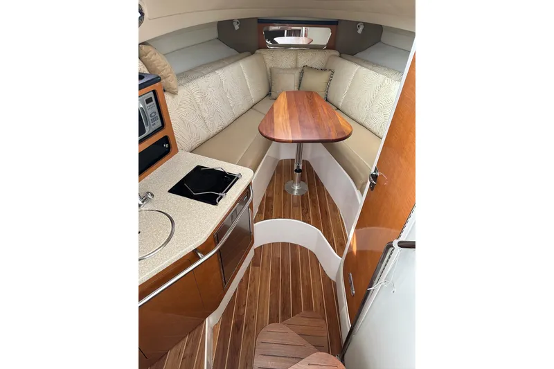 Slide: The Image of 2007 Robalo R305 Walkaround cabin interior with kitchenette and seating area. - 27