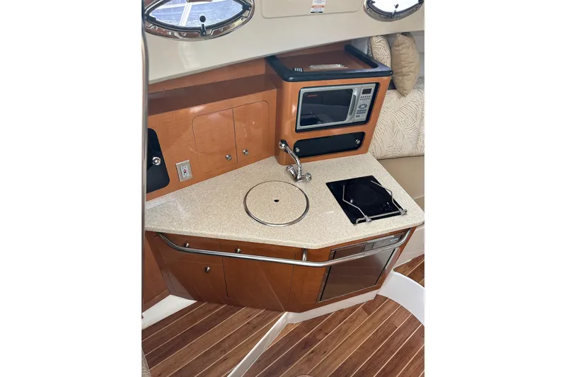 Slide: The Image of 2007 Robalo R305 Walkaround boat interior kitchen with microwave, sink, and stove. - 28
