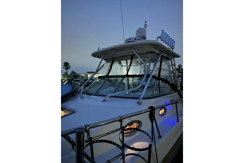 Slide: The Image of 2007 Robalo R305 Walkaround boat at dusk, featuring sleek design and illuminated cabin. - 3