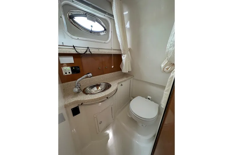 Slide: The Image of 2007 Robalo R305 Walkaround boat bathroom with sink, toilet, and porthole window. - 33