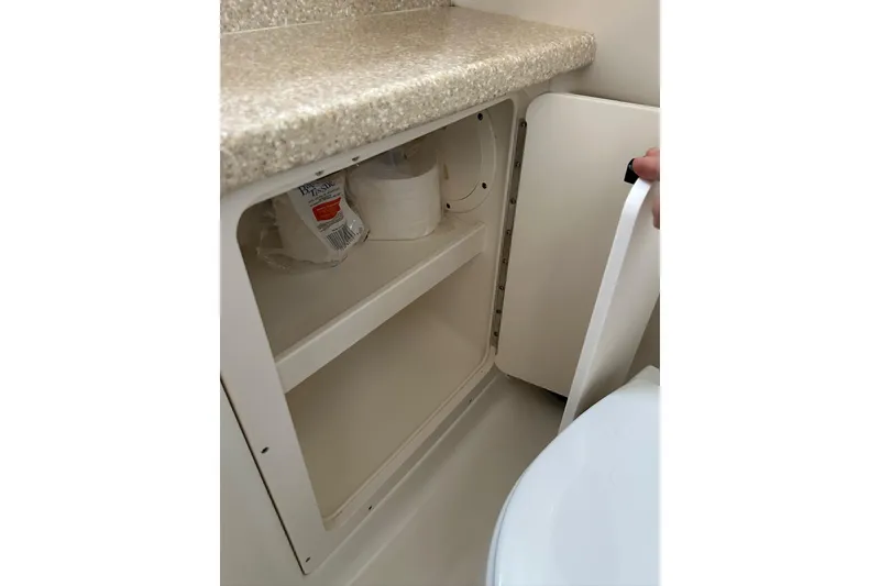 Slide: The Image of 2007 Robalo R305 Walkaround bathroom storage cabinet with toilet paper and cleaning supplies. - 36