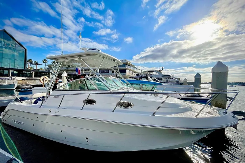 Slide: The Image of 2007 Robalo R305 Walkaround boat docked at marina under blue sky. - 4
