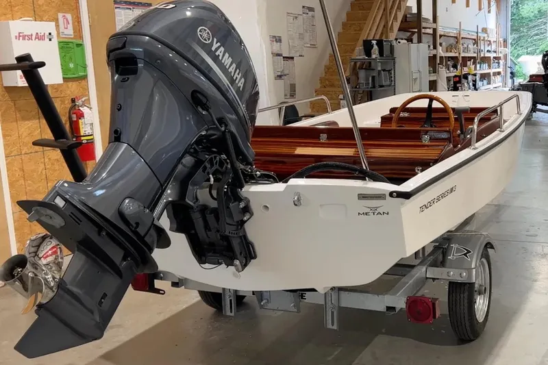 The Image of Manufacturer Provided Image: 2026 Metan Tender 13 boat with Yamaha outboard motor in a workshop setting. - 1