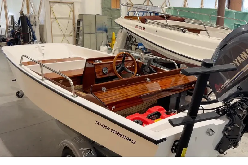 Slide: The Image of Manufacturer Provided Image: 2026 Metan Tender 13 boat in showroom, featuring sleek design and Yamaha outboard motor. - 2