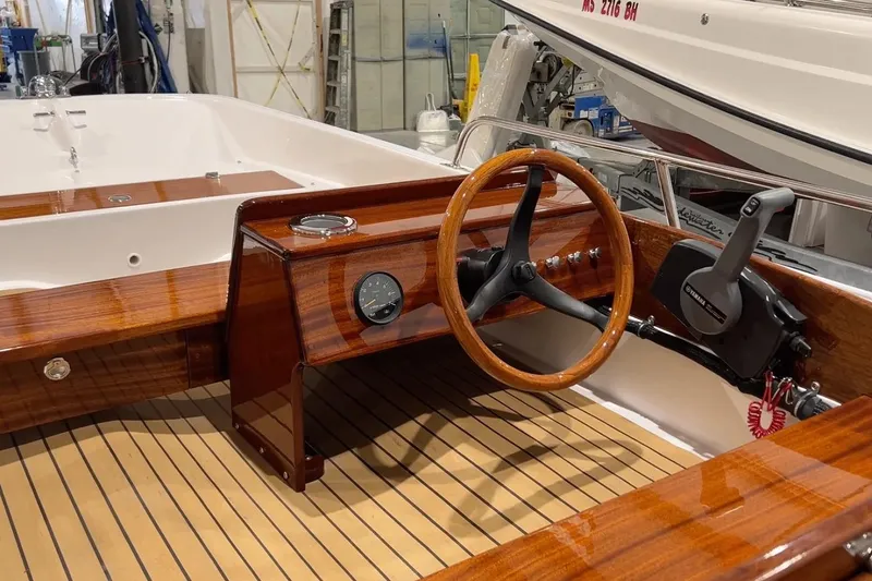 Slide: The Image of Manufacturer Provided Image: Interior of 2026 Metan Tender 13 boat with wooden steering wheel and dashboard. - 4