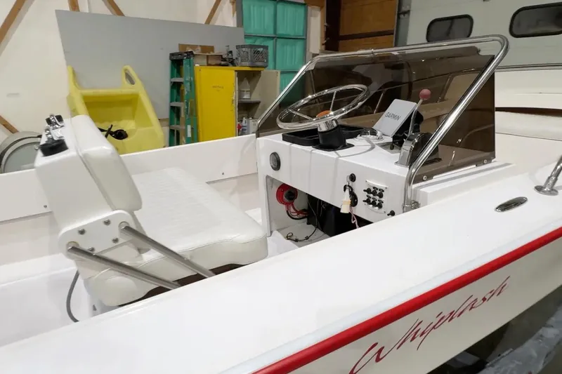 Slide: The Image of Manufacturer Provided Image: Interior of 2026 Metan Bristol 17 boat with steering console and white seating. - 2