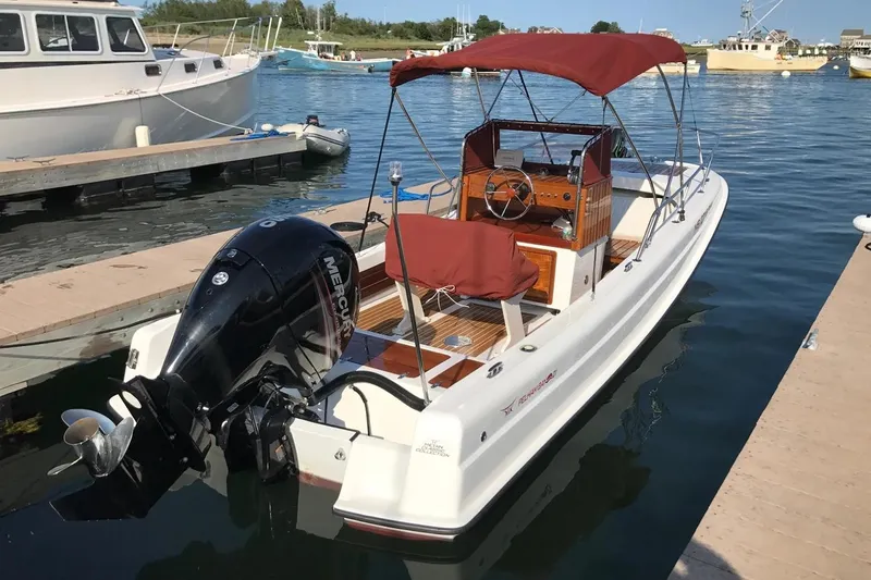 Slide: The Image of Manufacturer Provided Image: 2026 Metan Pelham Bay 21 Heritage Edition boat docked with red canopy and Mercury outboard motor. - 5