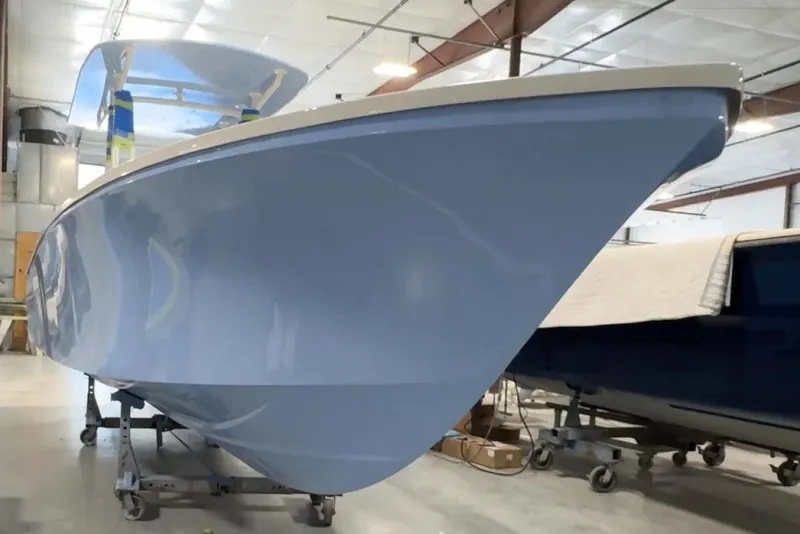 Slide: The Image of Manufacturer Provided Image: 2026 Metan Baretto Cove 26 boat in a workshop, showcasing sleek blue hull design. - 5
