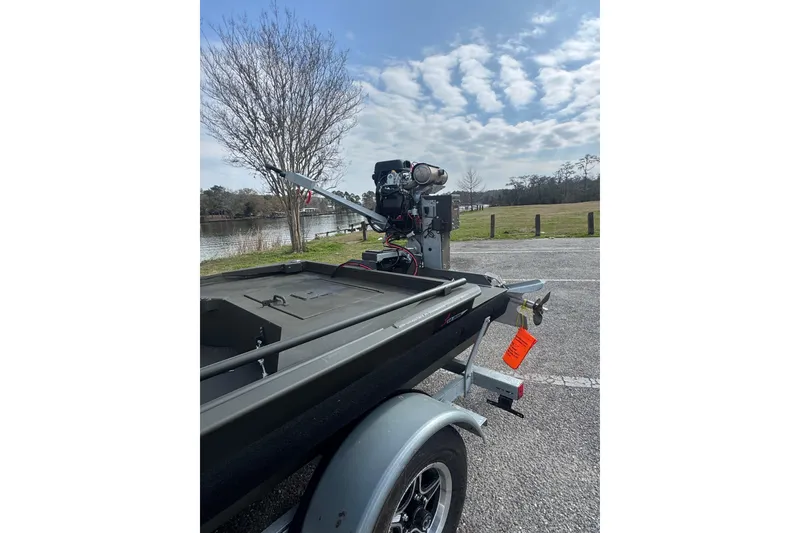 Slide: The Image of 2026 Go-Devil 18×60 Surface Drive Mud Boat on trailer by a lakeside. - 3