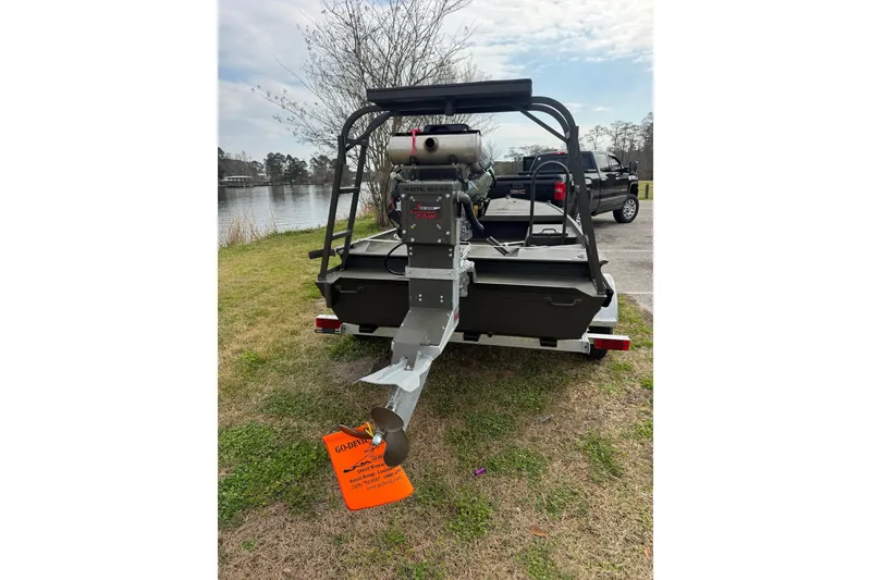 Slide: The Image of 2026 Go-Devil 18×60 Surface Drive boat on trailer by a lake. - 6