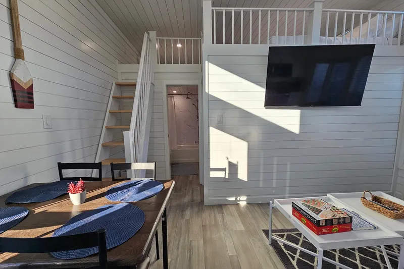 Slide: The Image of Modern 2025 houseboat interior with dining area, loft, and TV. - 11