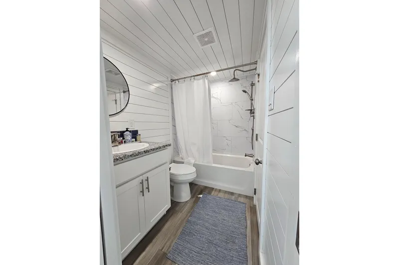 Slide: The Image of Modern 2025 houseboat bathroom with white decor, shower, and wooden flooring. - 13