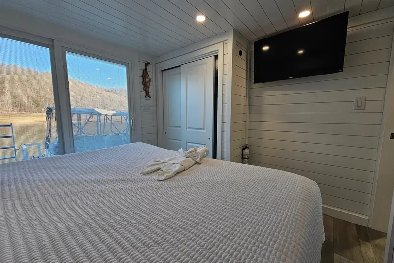 Slide: The Image of Modern 2025 houseboat bedroom with large window, TV, and cozy bed. - 15
