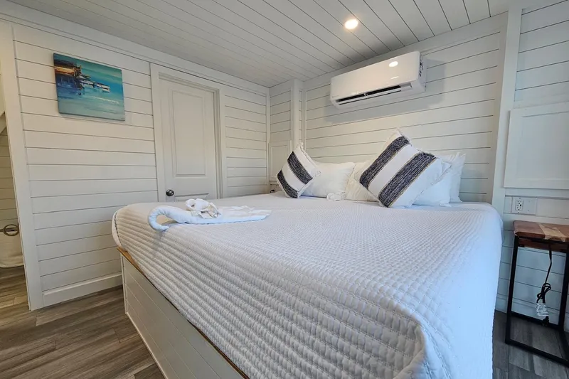 Slide: The Image of Modern 2025 houseboat bedroom with cozy bed, striped pillows, and air conditioning. - 18