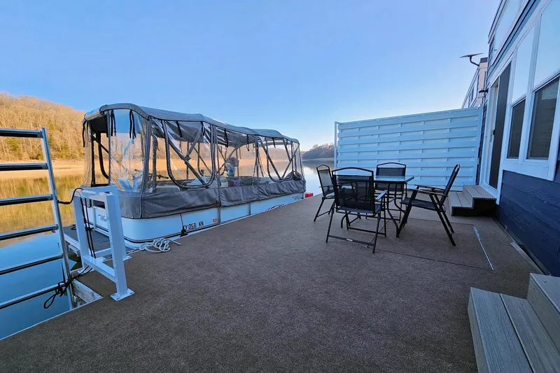 Slide: The Image of Houseboat float house 2025 with outdoor seating on a serene lake. - 3