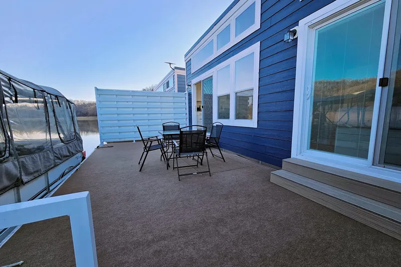 Slide: The Image of Houseboat float house 2025 with outdoor seating on a sunny deck. - 4