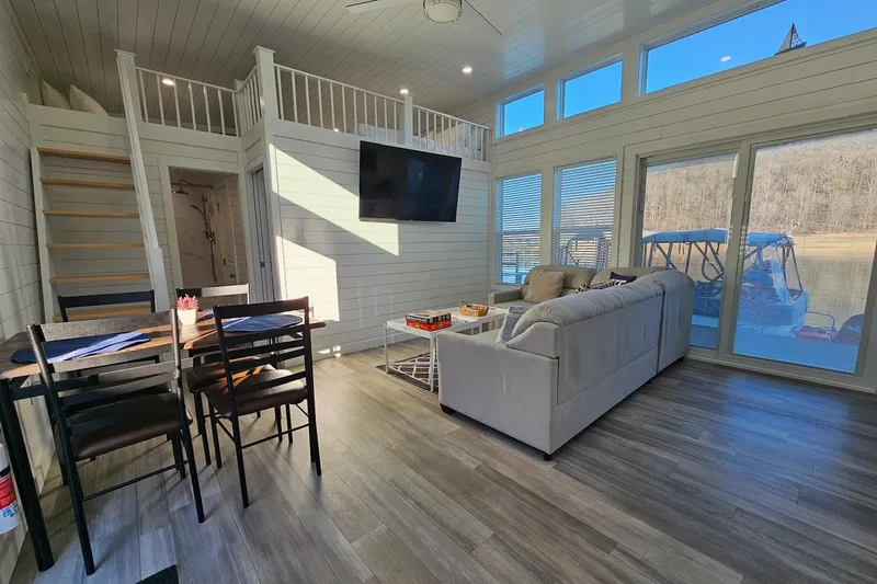 Slide: The Image of Modern 2025 houseboat interior with loft, dining area, and large windows overlooking the water. - 9