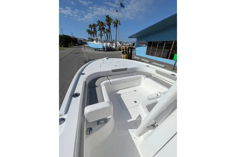 Slide: The Image of 2026 Caymas 281 HB boat interior with seating and console, parked on a street. - 7
