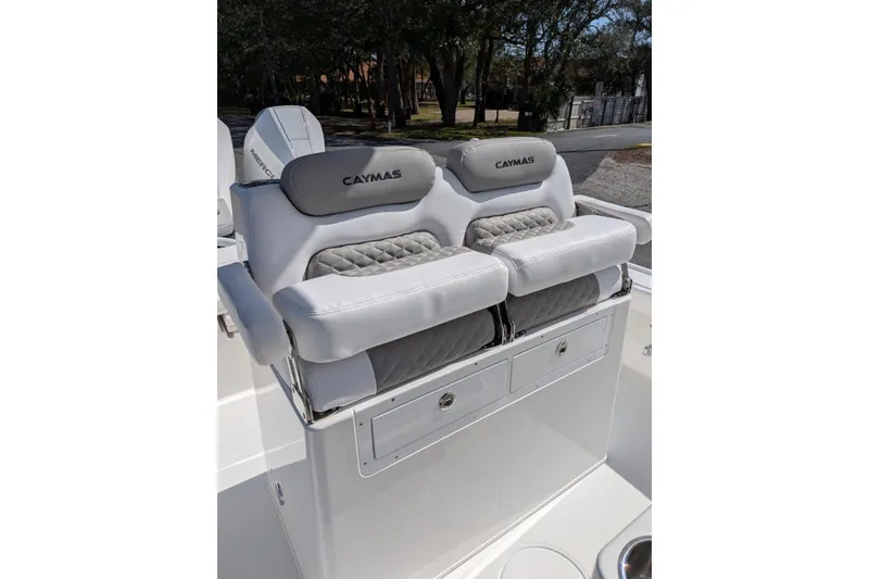 Slide: The Image of 2026 Caymas 281 HB boat with spacious deck, docked near palm trees and blue building. - 8