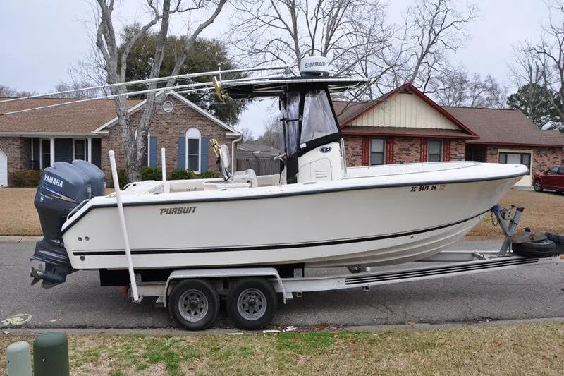 Slide: The Image of 2006 Pursuit 2570 Center Console boat on trailer, parked in suburban neighborhood. - 25