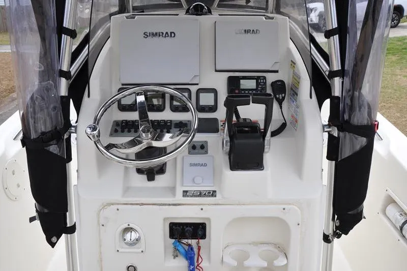 Slide: The Image of 2006 Pursuit 2570 Center Console boat dashboard with Simrad electronics and steering wheel. - 36