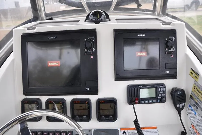 Slide: The Image of 2006 Pursuit 2570 Center Console dashboard with Simrad navigation displays and communication equipment. - 40