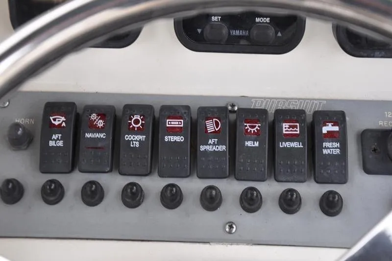 Slide: The Image of Control panel of a 2006 Pursuit 2570 Center Console boat with labeled switches. - 47