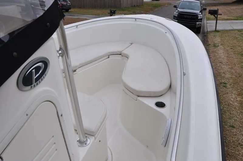 Slide: The Image of 2006 Pursuit 2570 Center Console boat with white seating and console, parked on grass. - 49