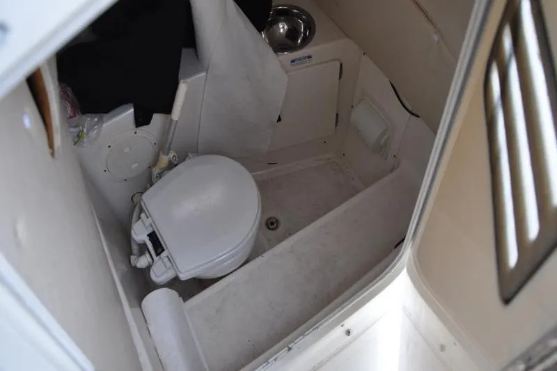 Slide: The Image of 2006 Pursuit 2570 Center Console boat interior with toilet and sink. - 50