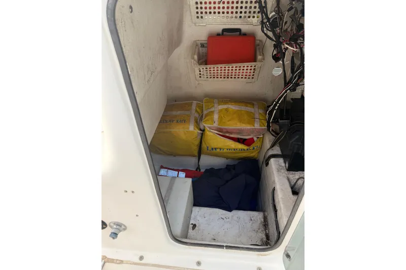 Slide: The Image of Storage compartment of a 2004 Cape Horn 24 boat with safety equipment and wiring. - 12