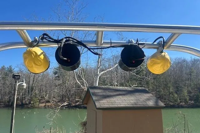 Slide: The Image of Boat tower speakers and yellow covers on a Centurion Lightning 2004, near a lake. - 13