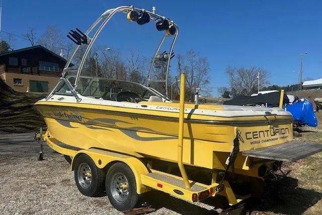 Slide: The Image of 2004 Centurion Lightning boat in yellow on a trailer, parked outdoors. - 4