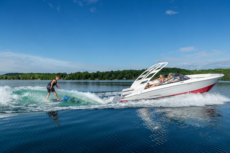 Slide: The Image of Surfer riding wave behind Regal LS2 Surf Ultimate 2026 boat. - 11