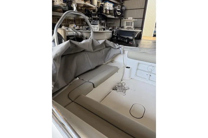 Slide: The Image of 2024 Key West 203 DFS boat interior with seating and storage in a warehouse. - 2