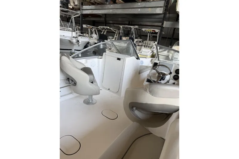 Slide: The Image of 2024 Key West 203 DFS boat interior with steering wheel and seating. - 4