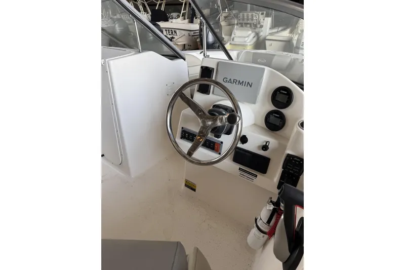 Slide: The Image of 2024 Key West 203 DFS boat dashboard with Garmin navigation system and steering wheel. - 5