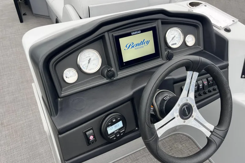 Slide: The Image of 2023 Bentley Pontoons 243 Navigator dashboard with steering wheel and digital display. - 11
