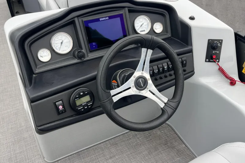 Slide: The Image of 2023 Bentley Pontoons 243 Navigator dashboard with steering wheel and control panel. - 12