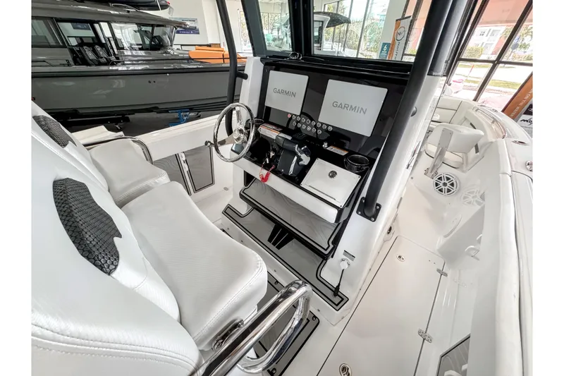 Slide: The Image of 2024 Wellcraft 263 Fisherman boat interior with dual Garmin displays and sleek white seating. - 12