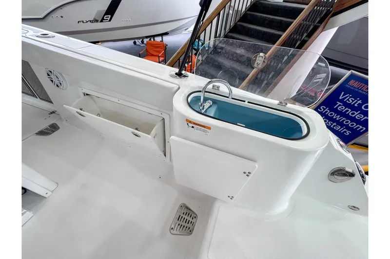 Slide: The Image of 2024 Wellcraft 263 Fisherman boat interior with storage and sink area. - 9