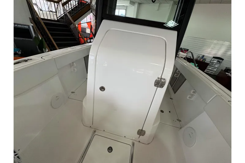 Slide: The Image of 2024 Wellcraft 263 Fisherman boat interior with white cabin door and seating area. - 19