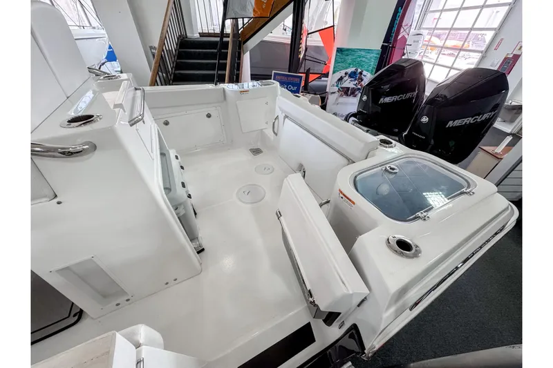 Slide: The Image of 2024 Wellcraft 263 Fisherman boat interior with dual Mercury engines, spacious deck, and seating. - 5