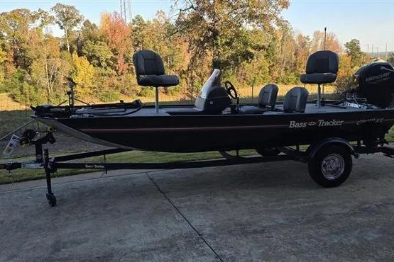 Slide: The Image of 2026 Tracker Bass Tracker Classic XL boat on trailer, parked outdoors with autumn trees in background. - 2